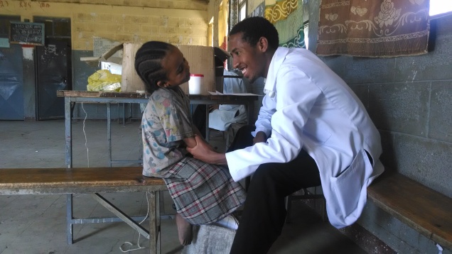 Little girl giving one of the pediatricians a laugh during her examination. This is from another school, but is my favorite photo from the rural outreach program. This photo may not be reproduced for any reason.